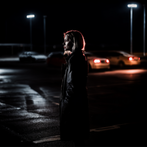 Žena na opuštěném parkovišti v noci